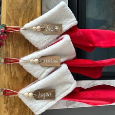 three santa hats with name tags on them