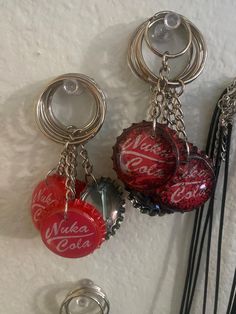 coca - cola bottle caps are hanging from the wall with key chains attached to them