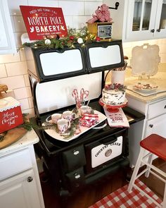 a stove top oven sitting inside of a kitchen next to a table with christmas decorations on it