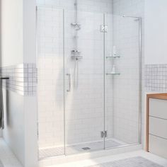 a white tiled bathroom with a walk in shower