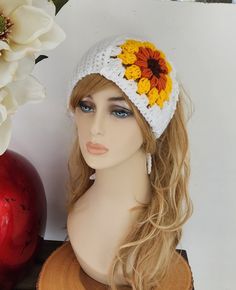 a mannequin head wearing a white hat with yellow and orange flowers on it