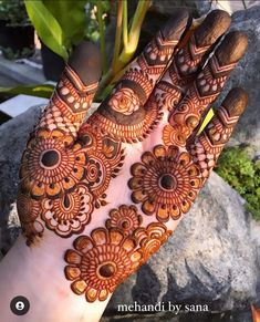 the hand is decorated with henna designs on top of it, and has an intricate pattern