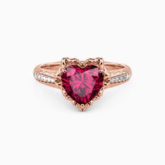 a heart shaped pink tourmaline ring with white diamonds on the sides and an open band