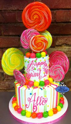 a birthday cake decorated with candy and lollipops