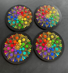 four coasters with colorful flowers painted on them