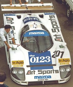 a man standing on top of a race car