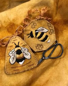 two bee patches are sitting next to a pair of scissors