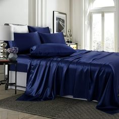 a bed with blue sheets and pillows in a room