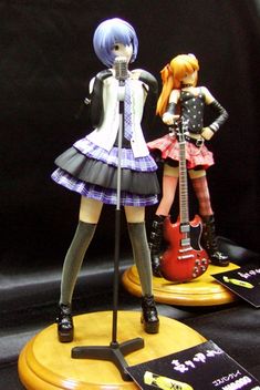 two anime figurines are posed next to each other with guitars in front of them