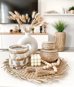 a white vase sitting on top of a table next to candles and other decor items