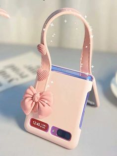 a pink cell phone case with a bow on the front and side, sitting on a table