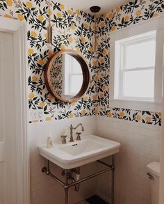 a white sink sitting under a bathroom mirror next to a wall mounted faucet