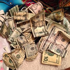 a pile of money sitting on top of a bed