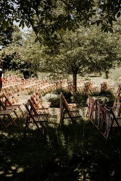 there are many wooden chairs set up in the grass for an outdoor ceremony or party