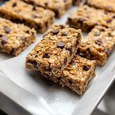 chocolate chip granola bars stacked on top of each other in a metal tray with more granola bars behind them