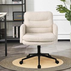 a white office chair sitting on top of a rug in front of a book shelf