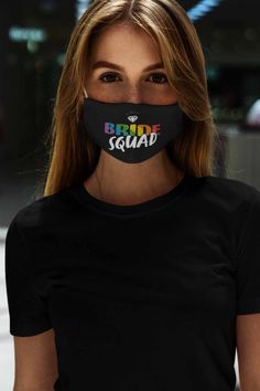 a woman wearing a black face mask with the words bride squad printed on it's side