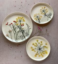 three plates with pressed wildflowers on them