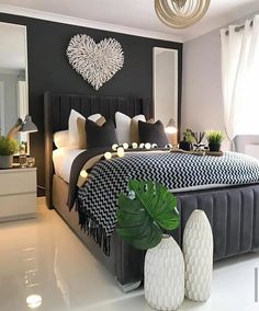 a bedroom with black and white decor on the walls, bedding, and pillows