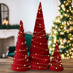 three red christmas trees sitting on top of a wooden table