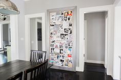 a dining room table and chairs in front of a wall with pictures on it's side