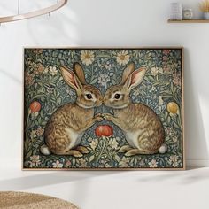 two rabbits sitting next to each other in front of a floral wallpaper with apples and flowers