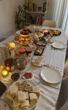 a table is set up with food and candles for a party or brunch