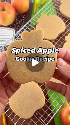 a person holding an apple cookie in front of some apples on a cooling rack with the words spiced apple cookie recipe