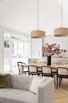 a living room filled with furniture next to a dining room table and chairs on top of a hard wood floor