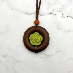 Squish Level: 8 Durability Level: 10 A fidget necklace meant to look like a succulent surrounded in dirt.  The cord has sliding knots so the length is adjustable. The longest length it can be adjusted to is about 32 inches, meaning it can hang down about 16 inches. You can twist the middle bead to fidget, or squish or chew on the pendent.  The entire pendent is made of a soft, smooth, food-grade silicone.  My fidget jewelry is for adults. Clean often with soap and warm water. Discard if the sili Earthy Green Adjustable Necklace, Adjustable Nature-inspired Pendant Necklaces, Nature-inspired Adjustable Pendant Necklaces, Adjustable Brown Necklaces For Everyday Use, Everyday Brown Necklace With Adjustable Length, Brown Adjustable Length Necklace For Everyday, Adjustable Necklace With Sliding Knot For Gifting, Adjustable Brown Necklaces With Sliding Knot, Adjustable Green Necklace For Everyday Use