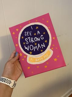 a person holding up a card with the words i see a strong woman on it