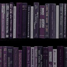 a row of purple books on a black shelf