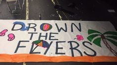 a sign that says drown the flyers with palm trees and beach balls on it in front of a building