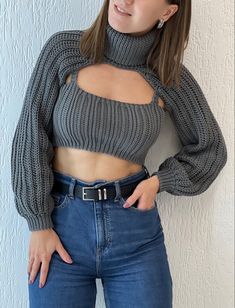 a woman wearing jeans and a sweater posing for the camera with her hands on her hips