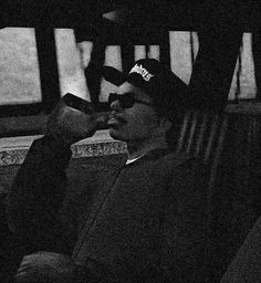 a man sitting on a bus wearing a hat and sunglasses