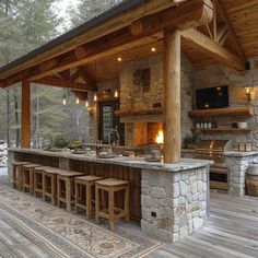 an outdoor kitchen and bar area with stone walls, wood flooring and wooden beams