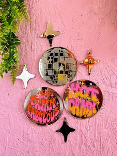 three mirrors on a pink wall with graffiti