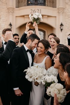 a bride and groom are surrounded by their wedding party