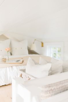 a white bed sitting in a bedroom next to a window