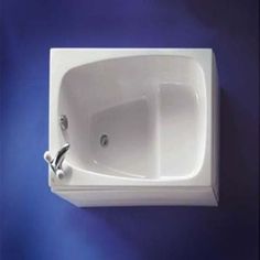 a white bath tub sitting on top of a blue wall next to a faucet