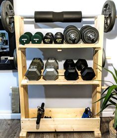 a gym rack with dumbs, weights and other personal care items on it in front of a white wall