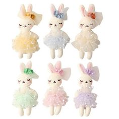 six small stuffed animals in different colors and sizes, one is wearing a tutu skirt