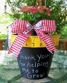 a potted plant sitting on top of a table with a measuring tape wrapped around it that says thank you for helping me to grow