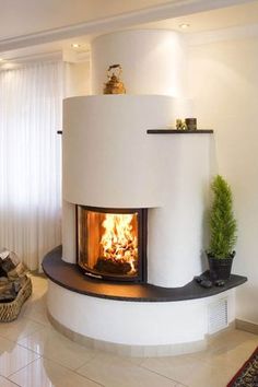 a fire place in the middle of a living room with white walls and flooring