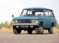 an old blue van is parked on the side of the road