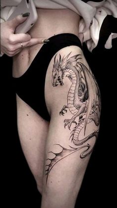 a woman with a dragon tattoo on her stomach holding a cell phone in her hand