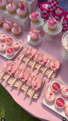 a pink table topped with lots of cupcakes