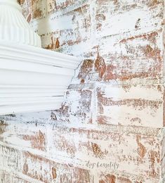 an old brick wall with white paint on it and a lamp hanging from the top