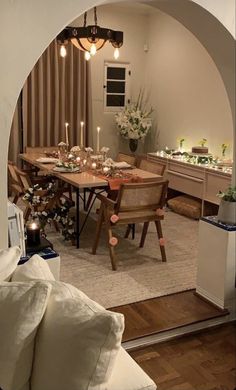 a dining room table with candles and flowers on it in the middle of a living room