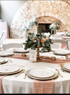 the table is set with white plates and place settings for an elegant dinner party or reception